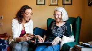 MSU Denver student Jackie Schwartz reads about Egyptology with resident Jeanne Dietrich in her room at Clermont Park Senior Living Community on May 17, 2023. Photo by Alyson McClaran